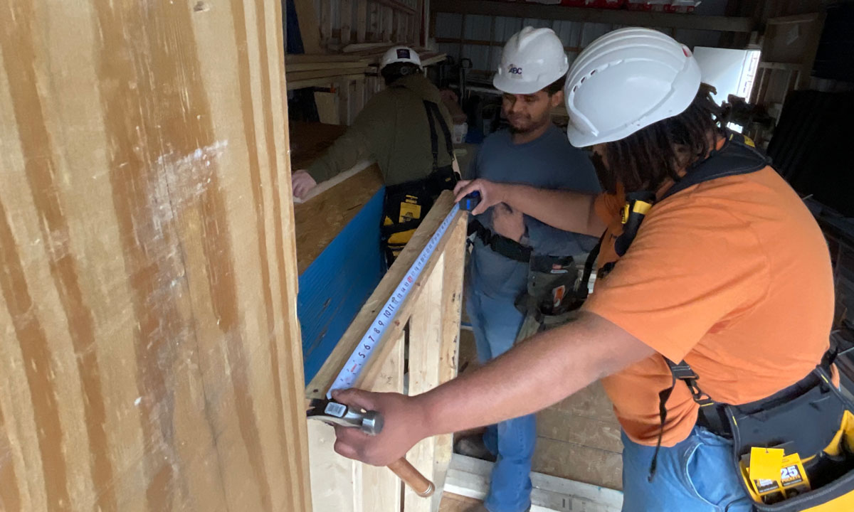 This is a photo of two students working on a construction project.