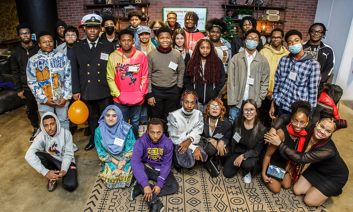 A group of about 30 students stand together for a photo